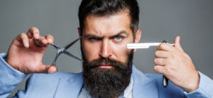 Man grooming his beard with a razor – modern men grooming routine and style care